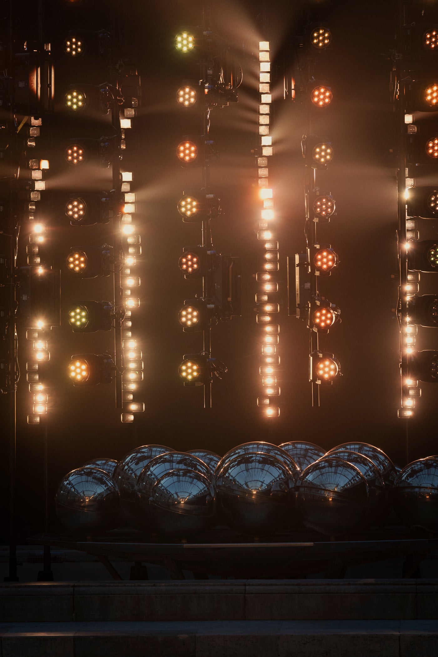 The runway set featuring the fountains of the Palais-Royal, illuminated by warm-colored spotlights in the background.